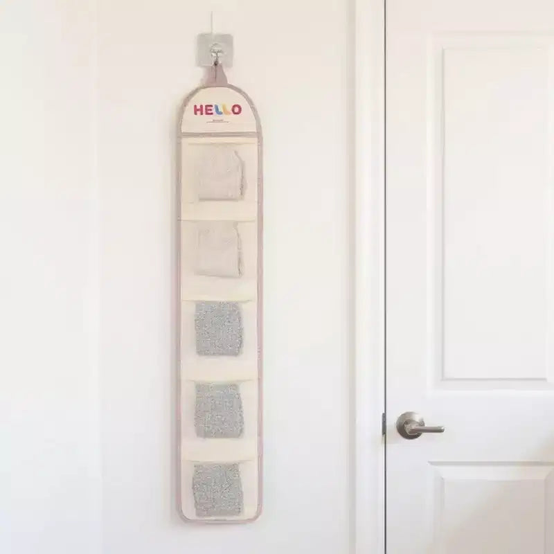 Organizador de pared colgante con múltiples bolsillos de malla y diseño estampado HELLO