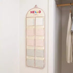 Organizador de pared colgante con múltiples bolsillos de malla y diseño estampado HELLO