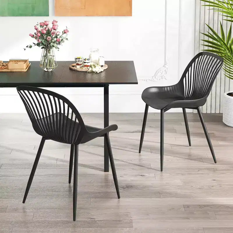 Silla de comedor de plástico con patas metálicas, respaldo recortado y asiento curvado