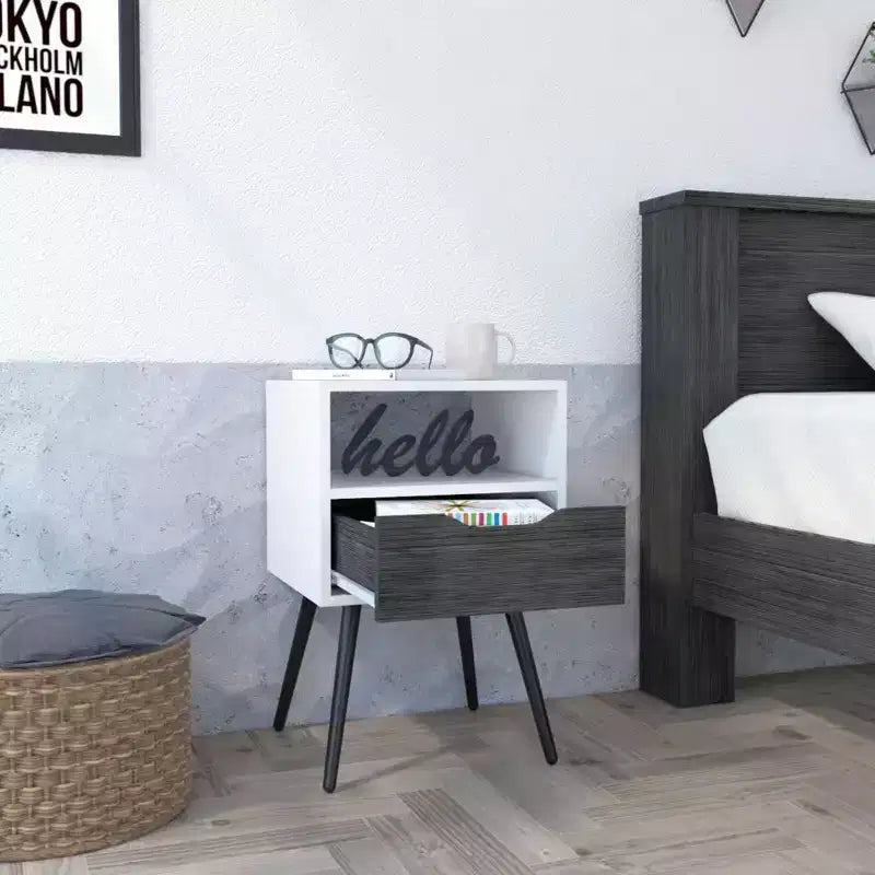 Con un diseño limpio y moderno, esta mesita de noche Fugaz con estante abierto, un solo cajón y acabado en roble ahumado/blanco ofrece almacenamiento práctico y una gran solidez.